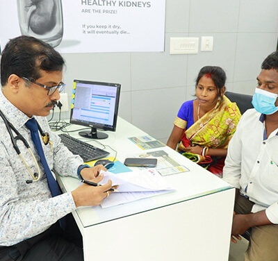 A doctor consults with their patient while seated at a desk.