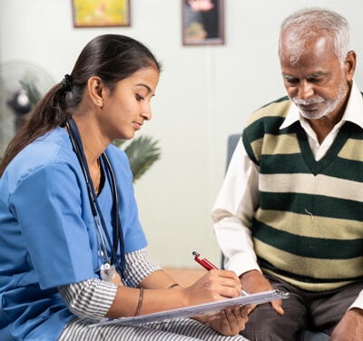 A nurse is writing on a clipboard in front of a patient.